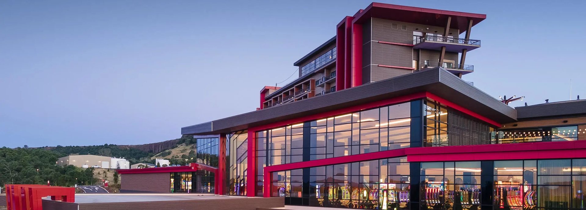 The glass and red-trimmed casino and hotel at Chicken Ranch Casino Resort in Jamestown, California, at dusk