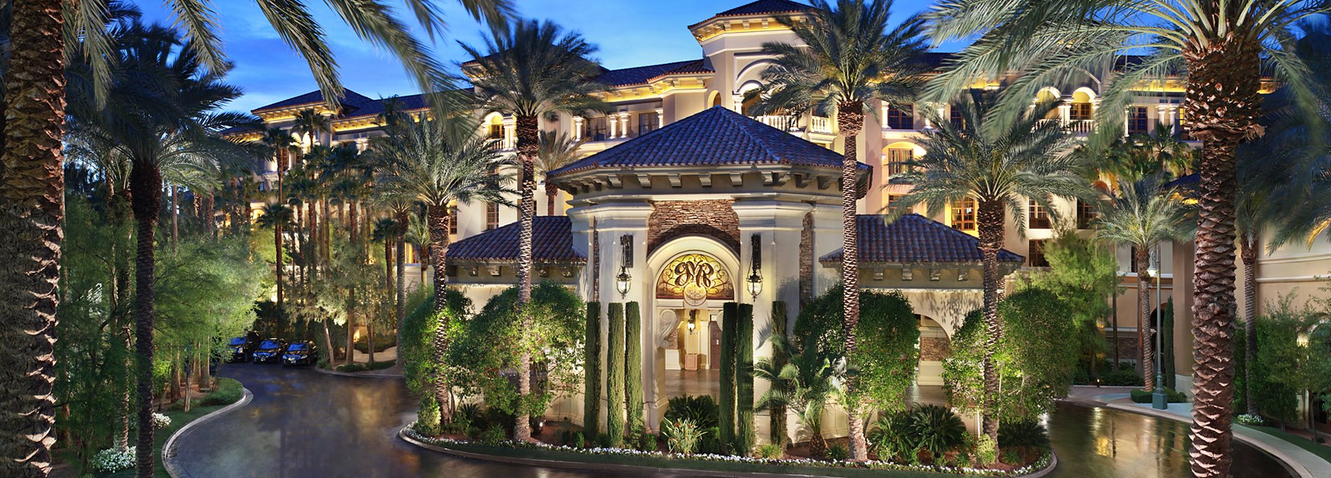 The palm-lined entrance of Green Valley Ranch Resort Spa Casino in Henderson, Nevada, lit up in the evening