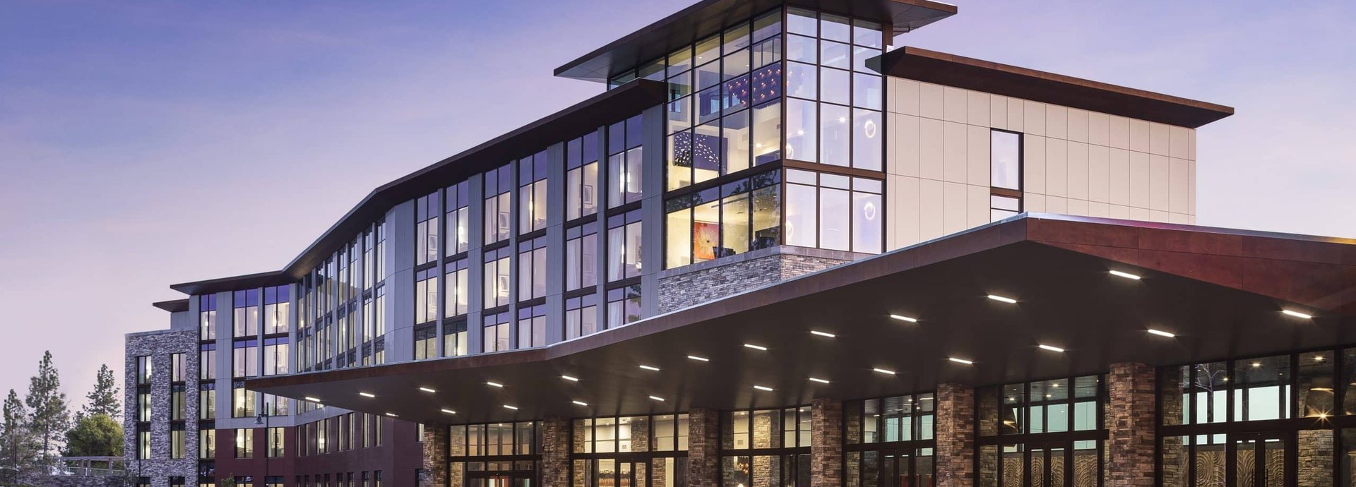 The hotel and entrance canopy at Red Hawk Resort + Casino in Placerville, California, lit up at dusk